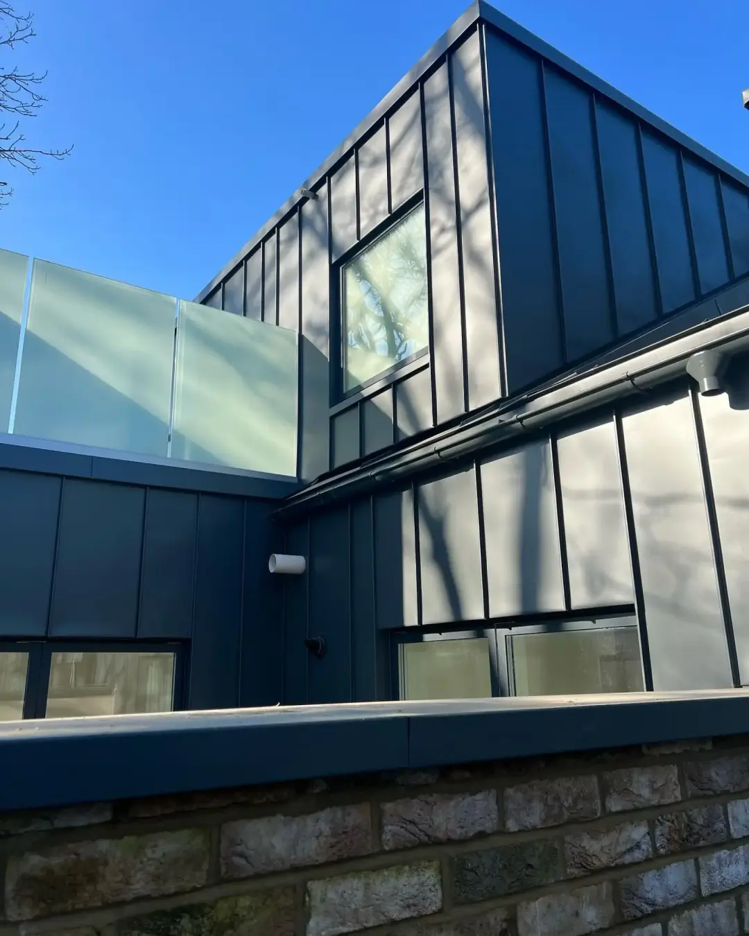 Dark standing seam zinc wall cladding on a modern extension in Fulham