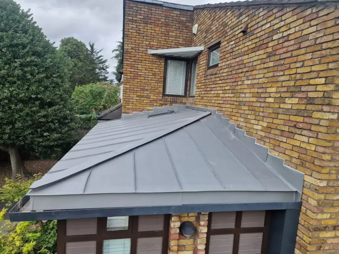 Grey standing seam zinc bay roof with folded hips in Wandsworth